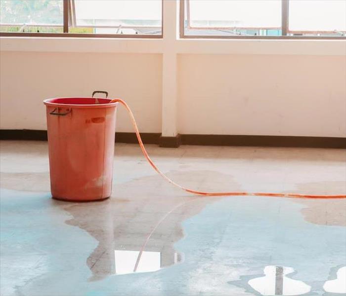 water damaged floor and a bucket